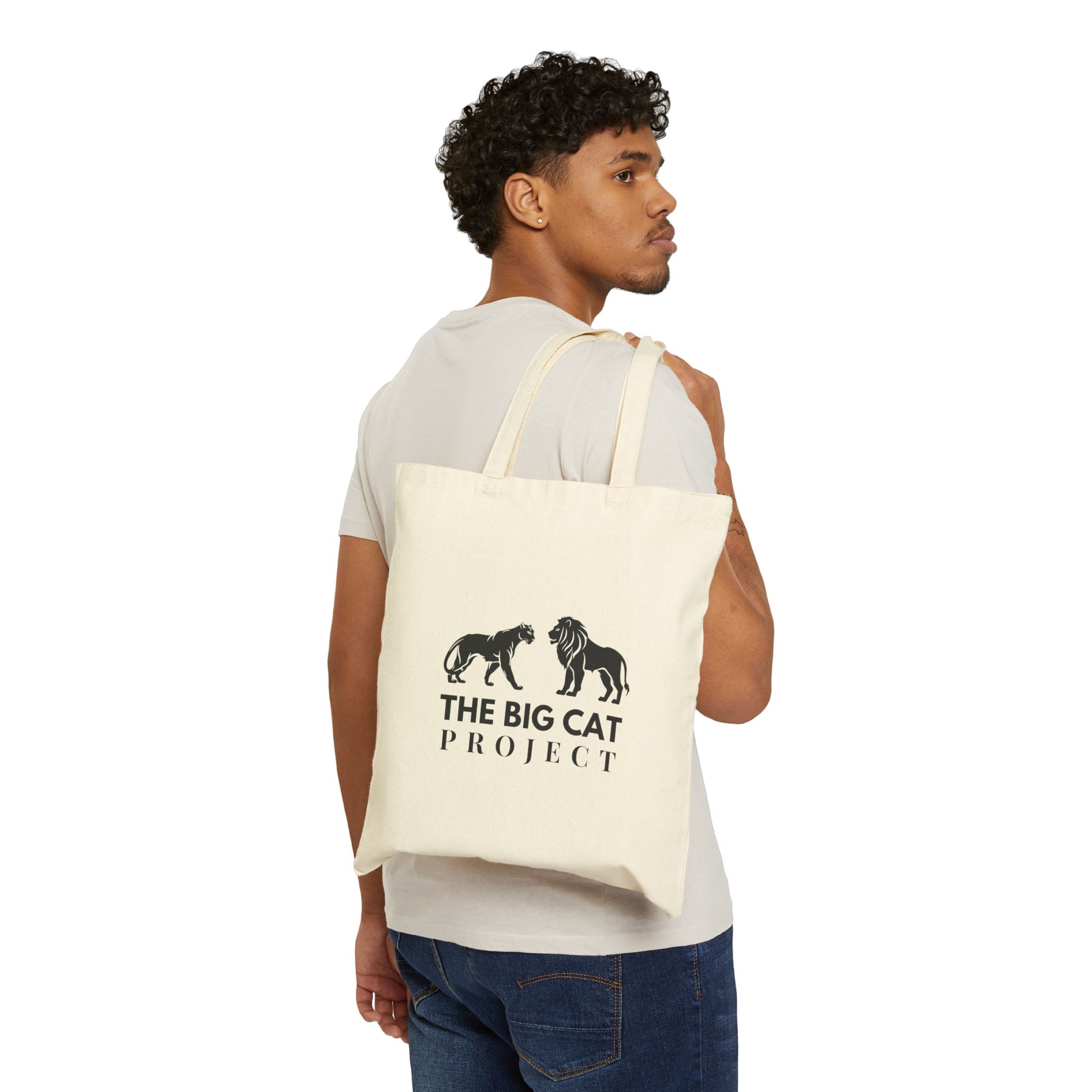 Man carrying a tote bag with 'The Big Cat Project' logo on a white background